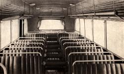Pohled do interiéru se dvěma řadami příčných dvoumístných sedadel a nouzovými vkládacími sedáky do prostoru uličky.