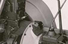 Detailní pohled na zvonovitý mezikus, pomocí něhož byla k motoru přišroubovaná jednotná čtyřrychlostní převodovka ZF typu K 30, za níž byl buben s pásovou ruční brzdou.
Dobře je na tomto snímku zřetelné zadní uložení motoru v masivních gumových silentblocích.