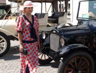 Chevrolet jest jedin�m americk�m automobilem, jeho� v�robce se sna�� udr�eti krok v l�ci s vozy Fordov�mi. To zra�� se zvl�t� v nen�padnosti a jednoduch�m lakov�n� v �ern�m t�nu, bez zbyte�n�ch leskle niklovan�ch dopl�k�. O to v�ce pak ov�em d�v� takov� v�z vyniknouti eleganci d�my, prov�zej�c� jeho jezdce! V pozad� luxusem se odli�uj�c�, n�padn� b�le lakovan�, v�z �E.M.F. Thirty�, p�na Sk�ly.