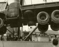 Archivní záběr „džímsy“ CCKW 353 se standardní plechovou kabinou, která se houpá na lanech vykládajícího jeřábu, je z Itálie, z května roku 1944.