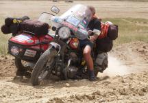 Na sv� vysn�n� cest� po trase z�vodu Peking-Pa�� zdol�v� Petr Ho���lek se svou Kawasaki W 650 s p��v�sn�m voz�kem Velorex t�k� ter�n pou�t� Gobi.