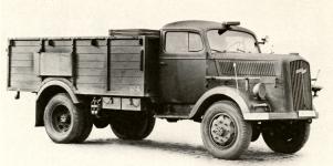 Tovární snímek valníku Opel-Blitz 3,6-6700 A (Allrad) s vysokými nesklápěcími bočnicemi pro dopravu mužstva. Vůz byl vybaven ručně ovladatelným „hledacím“ reflektorem na sloupku kabiny u řidiče, krumpáč na pravé a rýč na levé straně kapoty patřily, spolu se sekyrkou na předním blatníku, ke standardní předepsané výbavě.