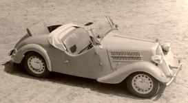 Pohled shora na Popular roadster - model 1937 s otevenm nouzovm sedadlem na zdi. Fotografie z osmdestch let, z pehldky historickch voz pi vro automobilky AZNP koda Mlad Boleslav. Na snmku jsou vidt nepvodn koncov svtla z Tudora, pidan blinkry do pednch i zadnch blatnk a popklice, pouit z vozu koda 440.